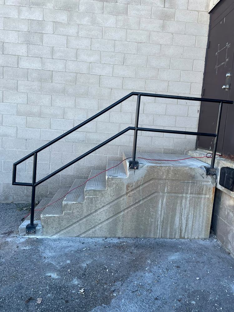 Same steps with a new black metal railing installed