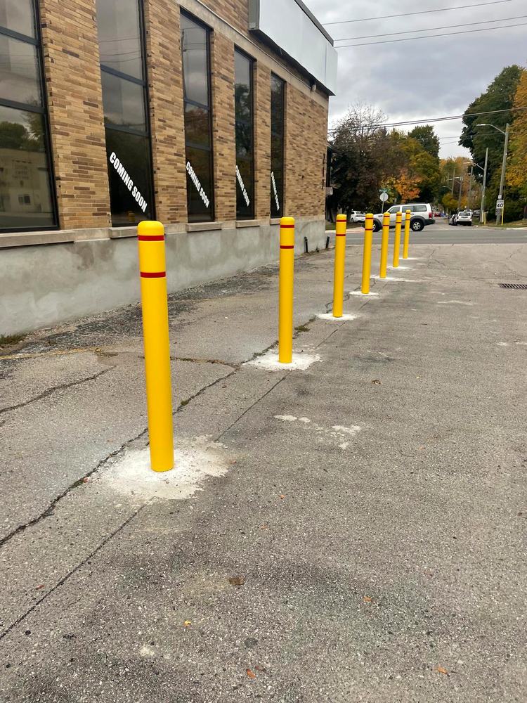 Yellow safety bollards finished along the building